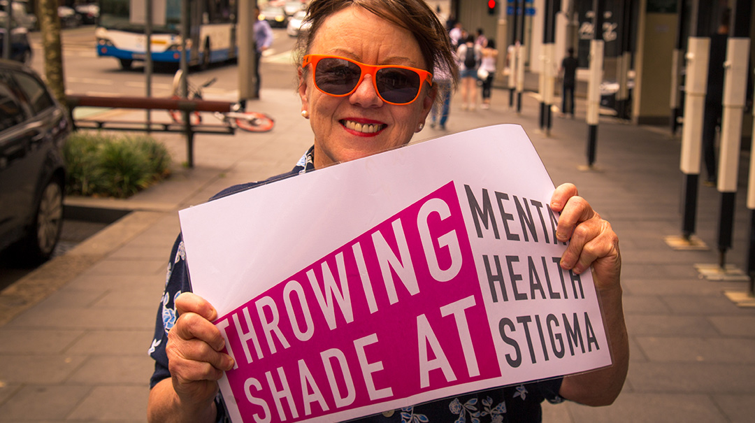 Liz showing off the new slogan launched by WayAhead, Being and Mental Health Carers NSW at Fair Day 2018