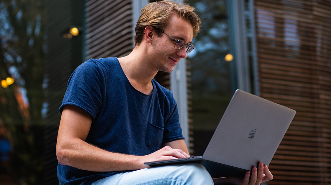 Man sitting outside on laptop