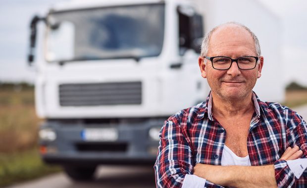 Older man standing in front of a truck